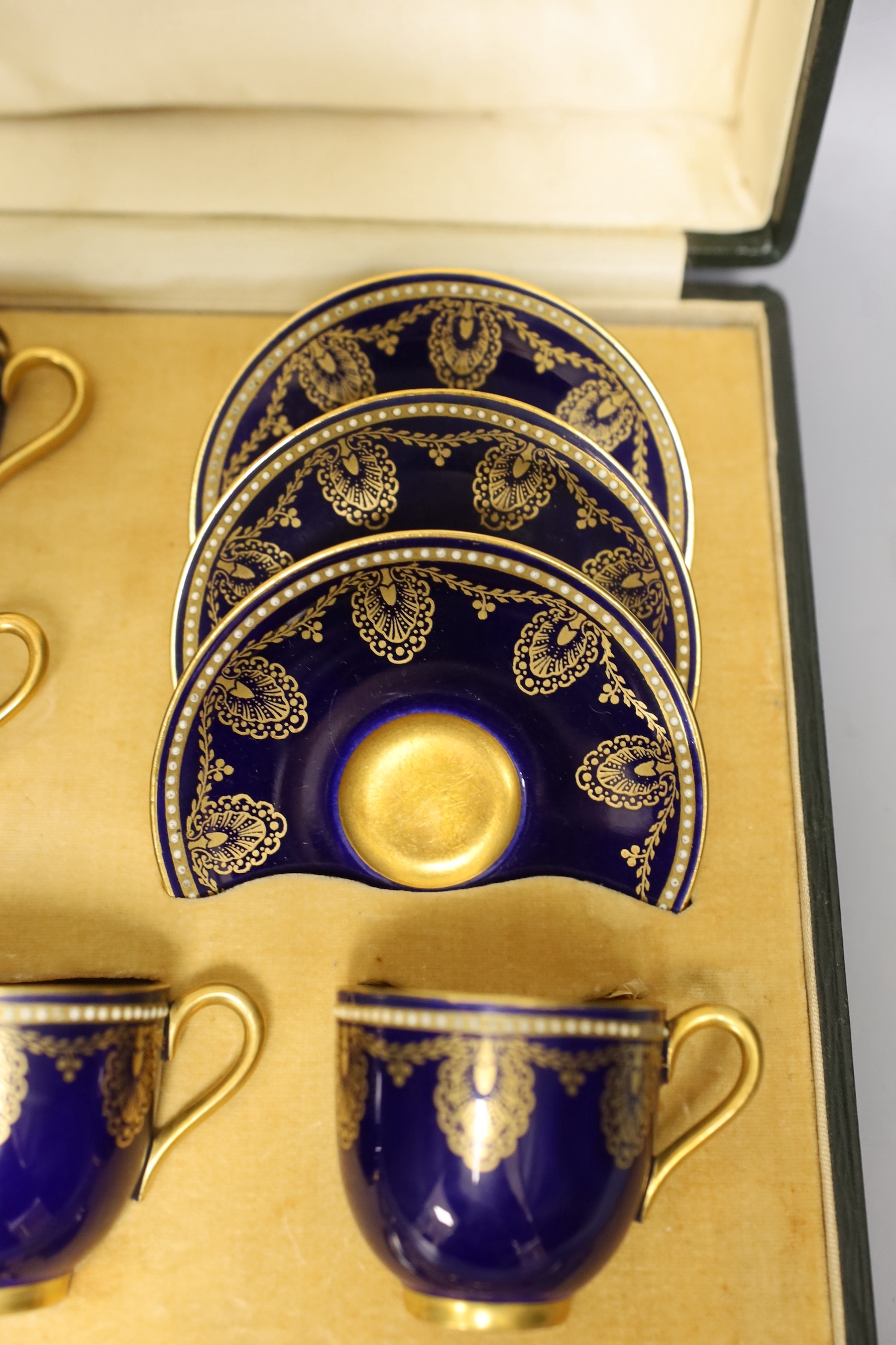 Boxed Royal Worcester blue coffee set with gilt stylised shell and swag design together with six silver coffee spoons; C899 and 6683